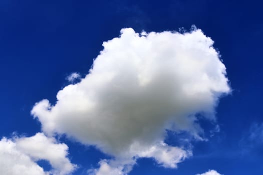 Beautiful fluffy white beautiful cloud formations in a deep blue summer sky