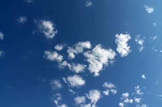 Beautiful fluffy white beautiful cloud formations in a deep blue summer sky