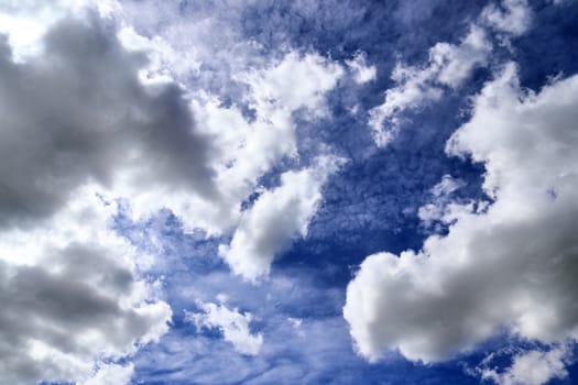 Beautiful fluffy white beautiful cloud formations in a deep blue summer sky