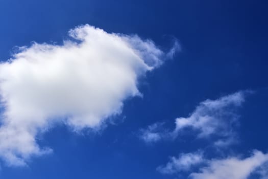 Beautiful fluffy white beautiful cloud formations in a deep blue summer sky