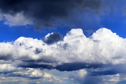 Beautiful fluffy white beautiful cloud formations in a deep blue summer sky