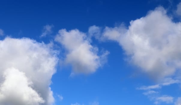 Beautiful fluffy white beautiful cloud formations in a deep blue summer sky