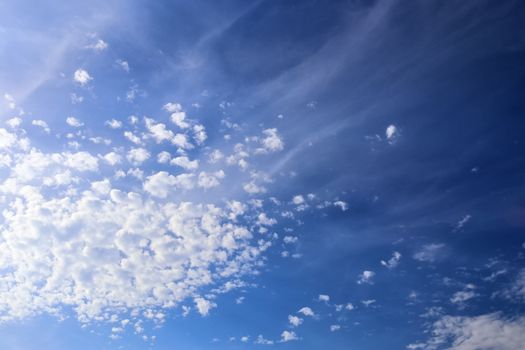 Beautiful fluffy white beautiful cloud formations in a deep blue summer sky