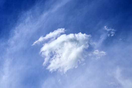 Beautiful fluffy white beautiful cloud formations in a deep blue summer sky