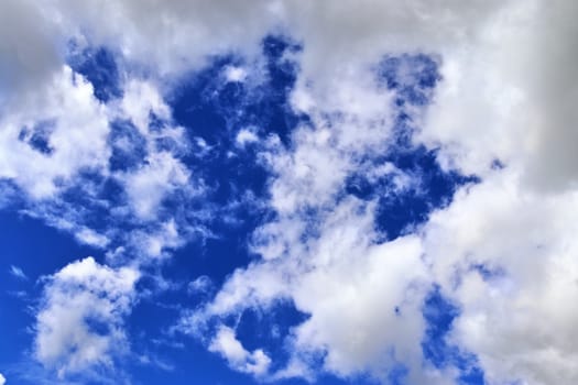 Beautiful fluffy white beautiful cloud formations in a deep blue summer sky