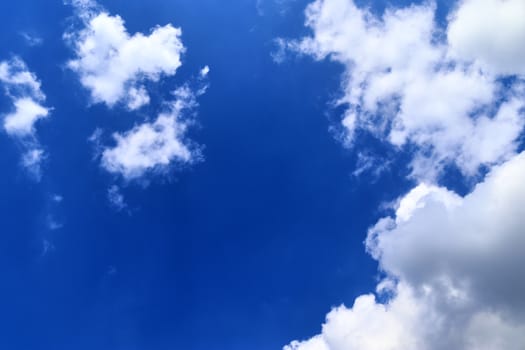 Beautiful fluffy white beautiful cloud formations in a deep blue summer sky