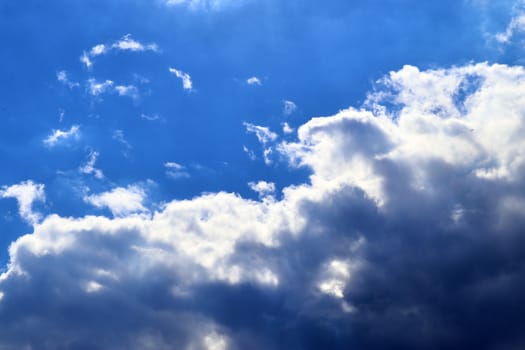 Beautiful fluffy white beautiful cloud formations in a deep blue summer sky