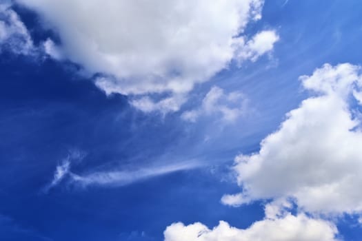 Beautiful fluffy white beautiful cloud formations in a deep blue summer sky