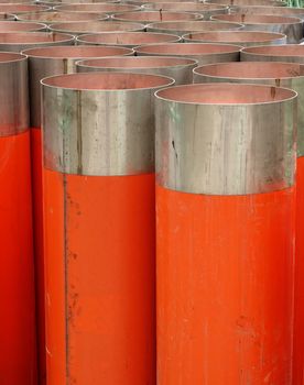 Large orange PVC pipes with stainless steel metal caps