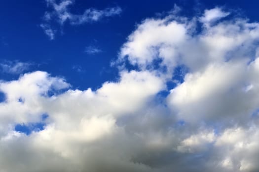 Beautiful fluffy white beautiful cloud formations in a deep blue summer sky