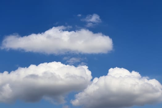 Beautiful fluffy white beautiful cloud formations in a deep blue summer sky