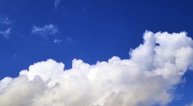 Beautiful fluffy white beautiful cloud formations in a deep blue summer sky