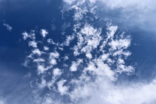 Beautiful fluffy white beautiful cloud formations in a deep blue summer sky