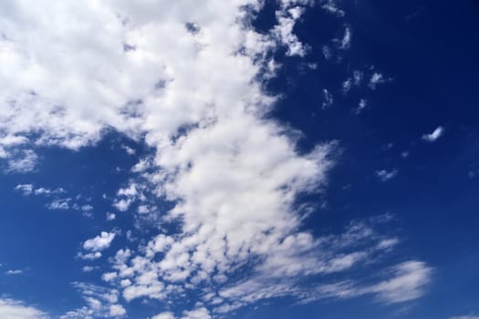 Beautiful fluffy white beautiful cloud formations in a deep blue summer sky