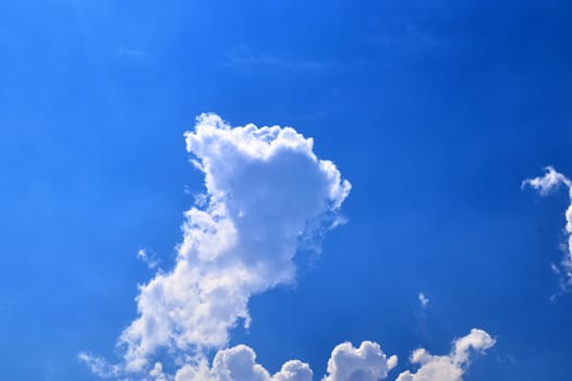 Beautiful fluffy white beautiful cloud formations in a deep blue summer sky