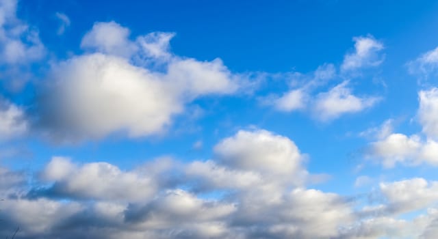 Beautiful fluffy white beautiful cloud formations in a deep blue summer sky