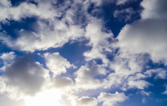 Beautiful fluffy white beautiful cloud formations in a deep blue summer sky