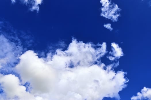 Beautiful fluffy white beautiful cloud formations in a deep blue summer sky