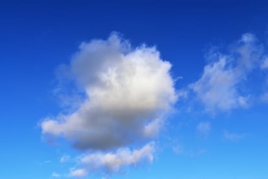 Beautiful fluffy white beautiful cloud formations in a deep blue summer sky