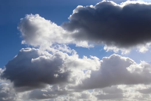 Beautiful fluffy white beautiful cloud formations in a deep blue summer sky