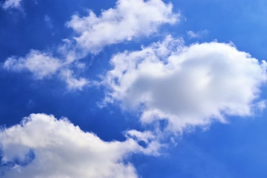 Beautiful fluffy white beautiful cloud formations in a deep blue summer sky