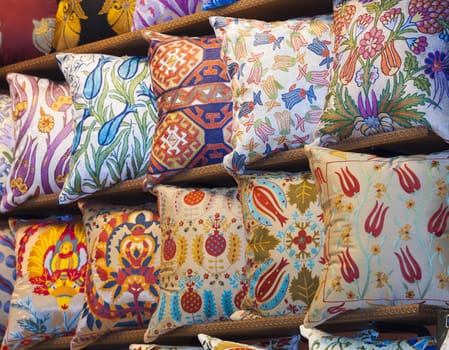 Display of ornately decorated cushions at an indoor market stall