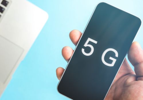 5G technology, Hand using mobile phone with 5g concept, internet on mobile smart phone and on blue background.