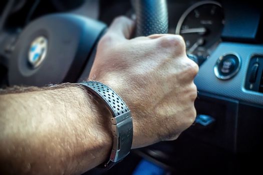 Vienna Austria May.19 2018, Hand of young adult man on steering wheel, driving a bmw