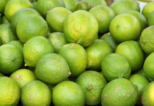 Fresh green lemons and limes for making juice