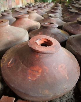 A multitude of handmade ceramic vessels lined up in rows