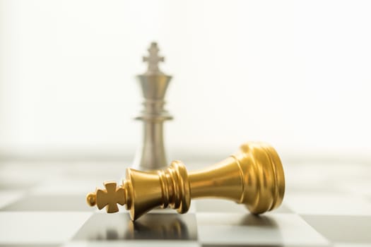 Sport board game, Business and planning concept. Closeup of falling gold and silver King chess piece on chessboard with copy space.