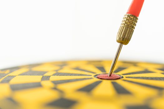 Sport, Business, Goal, Planning and Target Concept. Close up of red darts lace hit on center of black and yellow dart board