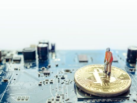 Vienna Austria September.23 2018, Miniature construction worker standing on physical Bitcoin, isolated mining concept