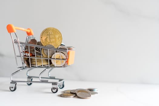 Bitcoin or cryptocurrency symbol in mini cart model full of coins money with copyspace white background.