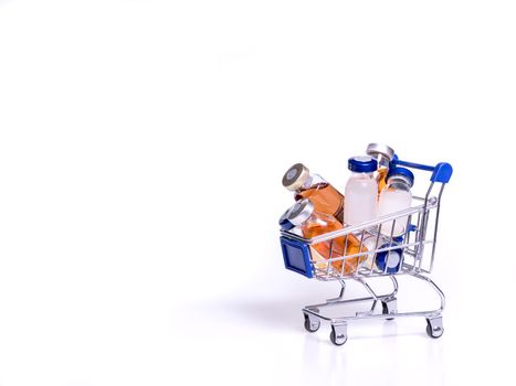 hand with blue latex glove reaching out for Medical vials with solution for injection in shopping cart, on white background. Vaccine for coronavirus concept.