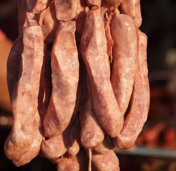 A bunch of freshly homemade sausages at an outdoor market
