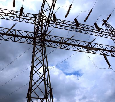 A large electricity pylon with ceramic insulators seen against a dramatic sky
