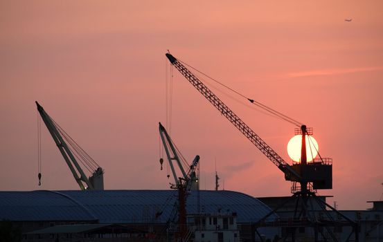 Cranes and docks at Kaohsiung Harbor in Taiwan at sunset time