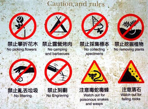 An old corroded sign with hiking rules in Chinese and English

