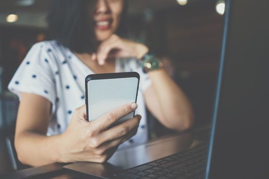 Woman hand use smartphone to do work business, social network, communication in public cafe work space area.