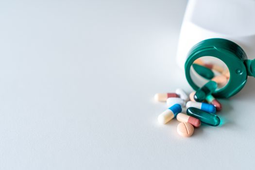 Top view of medicine tablets pour from pills bottle of marble texture white background. Health care medical lifestyle trend concept.