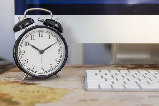 Business, Time, Technology Concept. Close up of vintage alarm clock with desktop computer and keyboard on working desk.