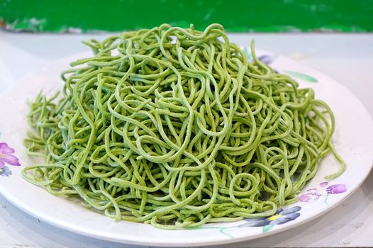 A plate with freshly made green pasta
