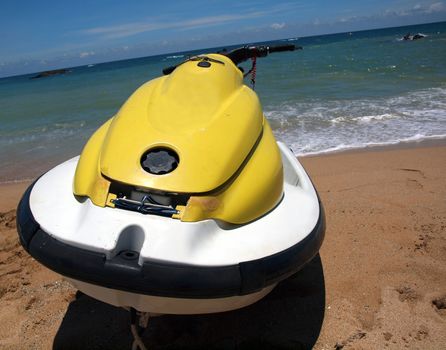 A personal watercraft rests on a beach