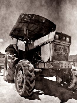 A rusting and corroded old tractor seen against a grungy background