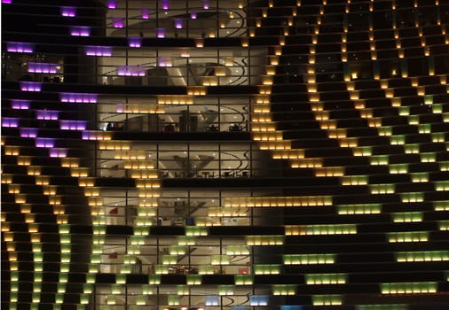 A lit up modern facade of a commercial building
