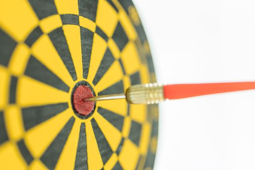 Sport, Business, Goal, Planning and Target Concept. Close up of red darts on center of black and yellow dart board