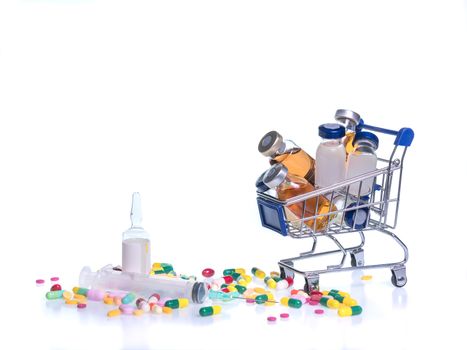 many medical vials in shopping cart with sterile water injection for diluted drug, syringe ,and tablets on white background. Medicines can be affordable and accessible concept.