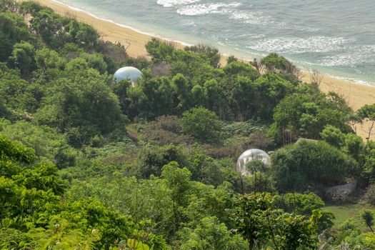 Bubble hotel at Nyang Nyang Beach on Bali Island, Indonesia. Romantic place ideal for honeymoon. A high reef off the coast of the Indian Ocean overgrown with dense tropical vegetation. Rainforest.