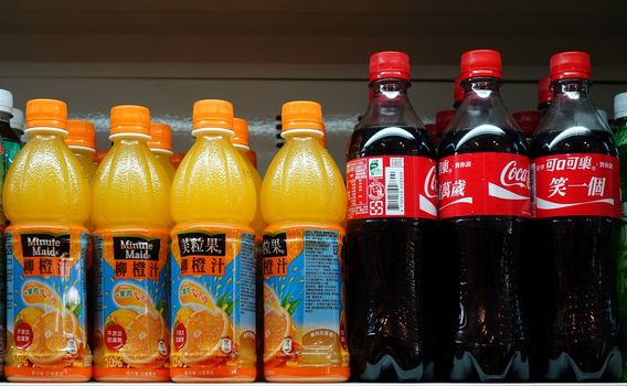 KAOHSIUNG, TAIWAN -- MARCH 14, 2014: A stall selling cold drinks displays Minute Maid orange drinks and Coca Cola bottles on its shelf.